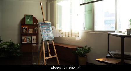 Einzigartiger Künstler-Arbeitsbereich mit Bücherregal, Kunstwerken, Malzubehör, Dekoration und eleganten persönlichen Dingen. Moderner Arbeitsraum für Künstler. Stockfoto