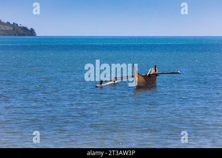 Ein Kanu, das im flachen Wasser vor einer Insel mit blauem Wasser driftet Stockfoto