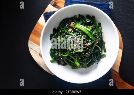 Food Concept Spot Focus koreanischer Spinatsalat auf schwarzem Hintergrund mit Kopierraum Stockfoto