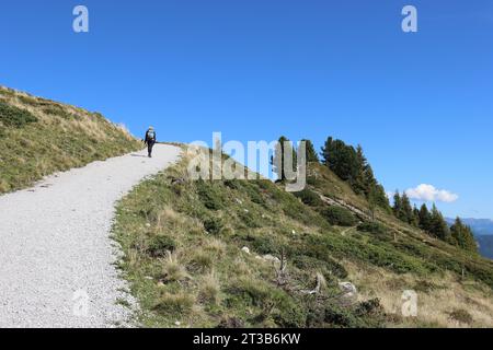 Blick auf einen Wanderweg in den Bergen, von einem Wanderer und vor einem klaren blauen Himmel, Blick von unten Stockfoto