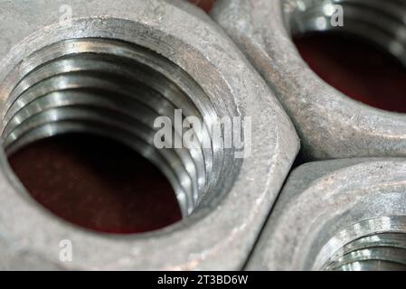 Gruppe verzinkter Stahlmuttern, abstrakter industrieller Hintergrund Stockfoto