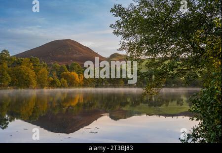 Melrose, Großbritannien. Oktober 2023. Wetter, Bowden Loch nahe Melrose, Scottish Borders, Schottland Ein kalter, sonniger Herbstmorgen am Bowden Loch oberhalb von Melrose in der schottischen Grenze, da der niedrige Nebel über dem stillen Wasser liegt und die Herbstfarben der Bäume und der Eildon Hills reflektiert. Bildnachweis: phil wilkinson/Alamy Live News Stockfoto