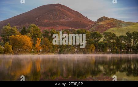 Melrose, Großbritannien. Oktober 2023. Wetter, Bowden Loch nahe Melrose, Scottish Borders, Schottland Ein kalter, sonniger Herbstmorgen am Bowden Loch oberhalb von Melrose in der schottischen Grenze, da der niedrige Nebel über dem stillen Wasser liegt und die Herbstfarben der Bäume und der Eildon Hills reflektiert. Bildnachweis: phil wilkinson/Alamy Live News Stockfoto