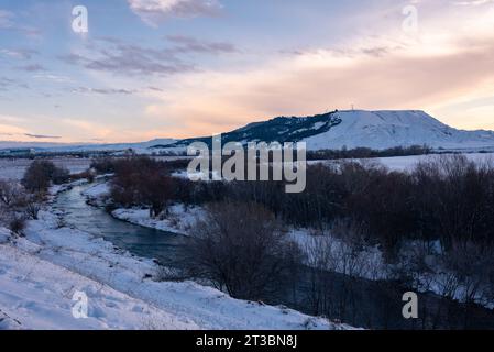 Wunderschöne Schneelandschaft nach einem Schneesturm mit einem Fluss und Bäumen ohne Blätter bei Sonnenuntergang im Winter, Torrejon de Ardoz, Madrid, Spanien Stockfoto