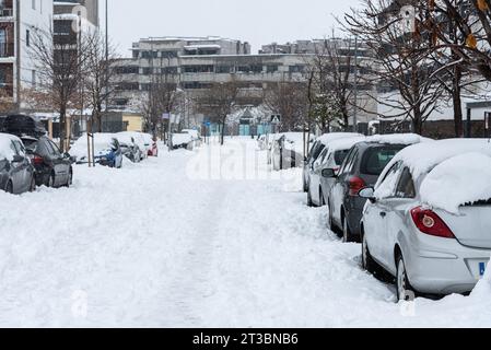 Verschneite Straßen und Autos, die während eines schweren Schneesturms im Winter mit Schnee bedeckt sind, Torrejon de Ardoz, Madrid, Spanien Stockfoto