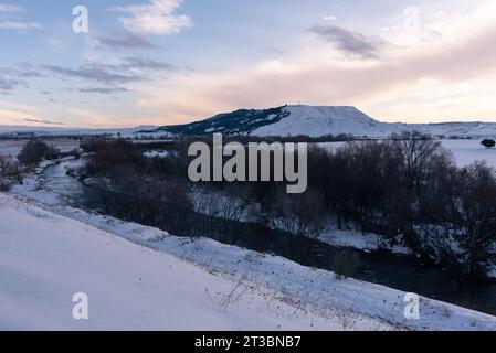 Wunderschöne Schneelandschaft nach einem Schneesturm mit einem Fluss und Bäumen ohne Blätter bei Sonnenuntergang, Torrejon de Ardoz, Madrid, Spanien Stockfoto