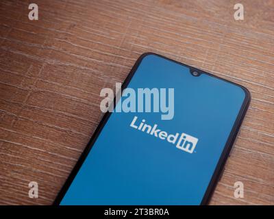 LOD, Israel - 16. Juli 2023: Startbildschirm der LinkedIn App auf Smartphone auf hölzernem Hintergrund. Draufsicht flach mit Kopierraum. Stockfoto