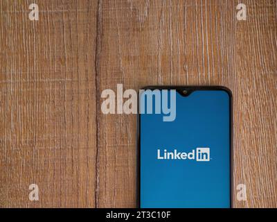 LOD, Israel - 16. Juli 2023: Startbildschirm der LinkedIn App auf Smartphone auf hölzernem Hintergrund. Draufsicht flach mit Kopierraum. Stockfoto