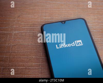 LOD, Israel - 16. Juli 2023: Startbildschirm der LinkedIn App auf Smartphone auf hölzernem Hintergrund. Draufsicht flach mit Kopierraum. Stockfoto