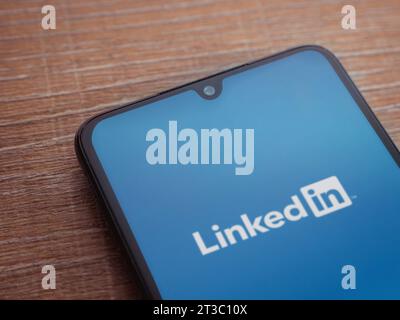 LOD, Israel - 16. Juli 2023: Startbildschirm der LinkedIn App auf Smartphone auf hölzernem Hintergrund. Draufsicht flach mit Kopierraum. Stockfoto