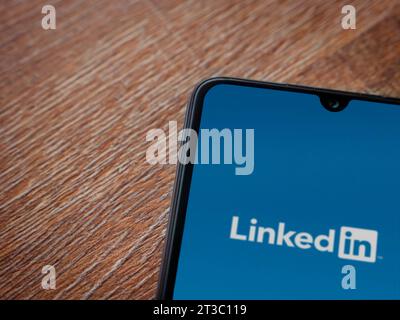 LOD, Israel - 16. Juli 2023: Startbildschirm der LinkedIn App auf Smartphone auf hölzernem Hintergrund. Draufsicht flach mit Kopierraum. Stockfoto