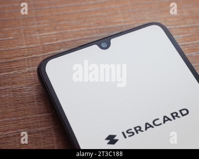 LOD, Israel - 16. Juli 2023: Startbildschirm der Isracard App auf Smartphone auf hölzernem Hintergrund. Draufsicht flach mit Kopierraum. Stockfoto