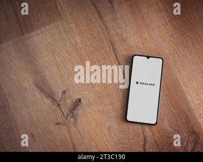 LOD, Israel - 16. Juli 2023: Startbildschirm der Isracard App auf Smartphone auf hölzernem Hintergrund. Draufsicht flach mit Kopierraum. Stockfoto