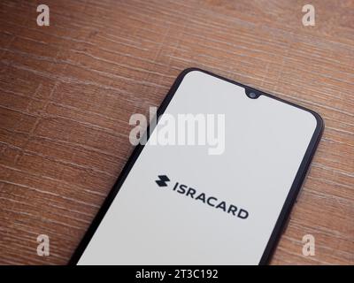 LOD, Israel - 16. Juli 2023: Startbildschirm der Isracard App auf Smartphone auf hölzernem Hintergrund. Draufsicht flach mit Kopierraum. Stockfoto
