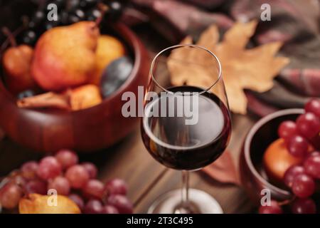 Herbststillleben mit Wein, Trauben und trockenen Blättern Stockfoto