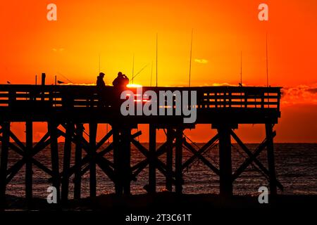 Isle Of Palms, Usa. Oktober 2023. Fischer, die von Sonnenaufgang umgeben sind, warten am Isle of Palms Pier am 24. Oktober 2023 in Isle of Palms, South Carolina, auf die Fische. Quelle: Richard Ellis/Richard Ellis/Alamy Live News Stockfoto