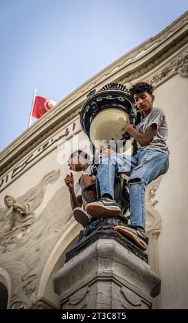 Die Jungs an der Straßenlaterne (mit der Flagge Tunesiens auf dem Hintergrund) während der propalästinensischen Kundgebung in Tunis Innenstadt nach der Krankenhausexplosion in Gaza Stockfoto