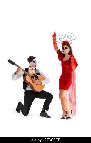 Junges Paar gekleidet für Mexikos Tag der Toten (El Dia de Muertos) mit Gitarre auf weißem Hintergrund Stockfoto