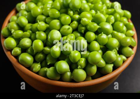 Perfekte frische grüne Erbsenbohnen in einer Tonschale aus Keramik, Nahaufnahme. Pflanzliches Protein, vegane Produkte, gesunde Lebensmittel. Stockfoto