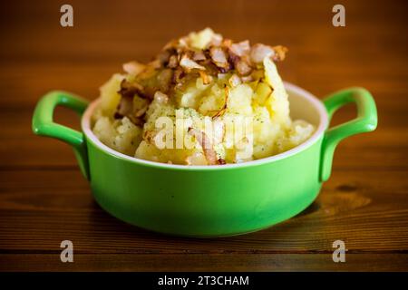 Gekochte Kartoffelpüree mit gebratenem Speck und Zwiebeln in einer Schüssel. Stockfoto