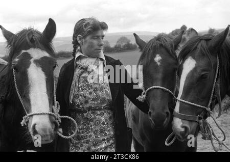 Roma-Frau in Schürze und traditionellem, locker gebundenem Halstuch, sie „zeigt“ Pferde, die zum Verkauf stehen. Appleby in Westmorland Gypsy Horse Fair Cumbria, England Juni 1981 1980s UK Charter Fair gewährt von König James II. 1685 HOMER SYKES Stockfoto