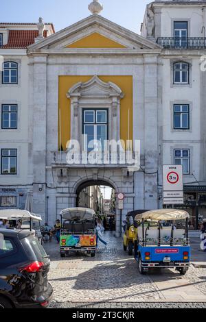 Tuk Tuks fahren am 12. Oktober 2023 durch den Bogen vom Rossio-Platz zur Rua dos Sapateiros in Lissabon, Portugal Stockfoto