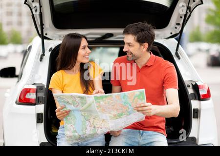Junger Mann und Frau, die zusammen Auto fahren, Karte lesen Stockfoto