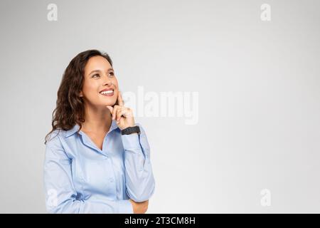 Eine glückliche nachdenkliche kaukasische Geschäftsfrau in formeller Kleidung denkt, sieh dir den leeren Raum an Stockfoto