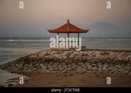 Morgenlandschaft am Sandstrand. Blick über das Meer auf den Vulkan Mount Agung. Panorama des Sonnenaufgangs am Sandstrand von Sanur Stockfoto