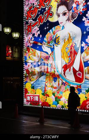 Person, die vor dem Neonschild in Tokio läuft Stockfoto