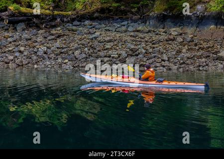 Frau Kajakfahren in der schwimmenden Lodge der Moresby Explorers im Gwaii Haanas National Park Reserve, Haida Gwaii, British Columbia, Kanada [kein Model r Stockfoto