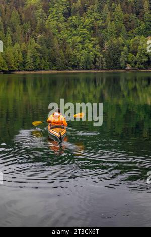 Frau Kajakfahren in der schwimmenden Lodge der Moresby Explorers im Gwaii Haanas National Park Reserve, Haida Gwaii, British Columbia, Kanada [kein Model r Stockfoto