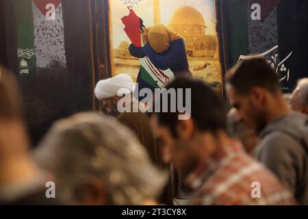 Teheran, Iran. Oktober 2023. Iranische Männer beten neben einem manipulierten Bild einer palästinensischen Frau während einer Gebetszeremonie, um Solidarität und Unterstützung für Gaza am heiligen Schrein von Imamzade Saleh im Norden Teherans zum Ausdruck zu bringen. (Kreditbild: © Rouzbeh Fouladi/ZUMA Press Wire) NUR REDAKTIONELLE VERWENDUNG! Nicht für kommerzielle ZWECKE! Stockfoto