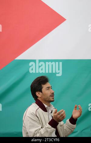 Teheran, Iran. Oktober 2023. Ein afghanischer Mann betet neben einer riesigen palästinensischen Flagge während einer Gebetszeremonie, um Solidarität und Unterstützung für Gaza am heiligen Schrein von Imamzade Saleh im Norden Teherans zum Ausdruck zu bringen. (Kreditbild: © Rouzbeh Fouladi/ZUMA Press Wire) NUR REDAKTIONELLE VERWENDUNG! Nicht für kommerzielle ZWECKE! Stockfoto