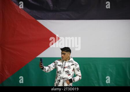 Teheran, Iran. Oktober 2023. Ein junger iranischer Mann macht ein Selfie neben einer riesigen palästinensischen Flagge während einer Gebetszeremonie, um Solidarität und Unterstützung für Gaza am heiligen Schrein von Imamzade Saleh im Norden Teherans zum Ausdruck zu bringen. (Kreditbild: © Rouzbeh Fouladi/ZUMA Press Wire) NUR REDAKTIONELLE VERWENDUNG! Nicht für kommerzielle ZWECKE! Stockfoto