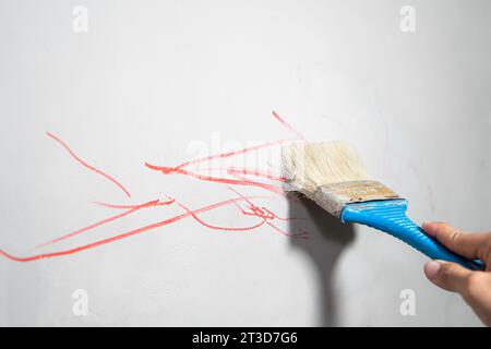 Männliche Handmalerei Wand mit Malerwalze. Stockfoto