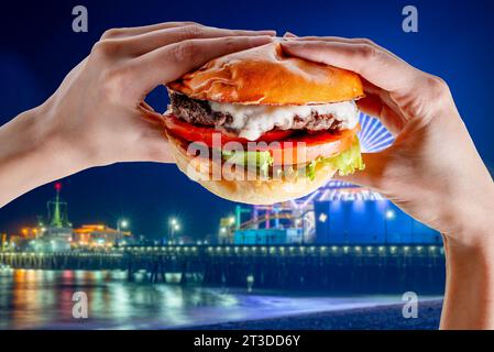 Burger in Händen über Santa Monica halten Stockfoto