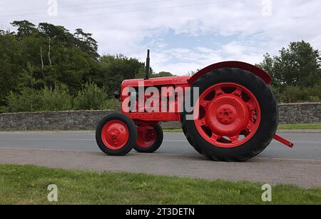 Alter Traktor auf der Straße in roter Farbe. Stockfoto