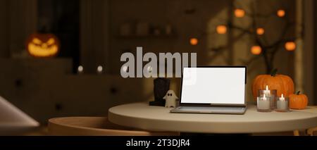 Ein Laptop-Modell mit weißem Bildschirm, Kerzen und Halloween-Accessoires auf einem Tisch in einem modernen dunklen Raum im Halloween-Thema. Arbeitsbereich im Halloween-Thema. 3D Stockfoto