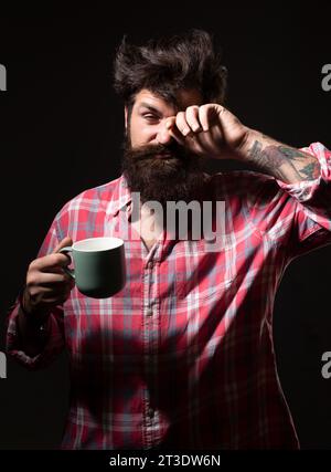 Happy Morning. Mans hält eine Tasse Kaffee. Morgentee. Guten Morgen. Mann mit Teetasse. Hipster-Mann mit einer Tasse Kaffee. Bärtiger Mann, der lächelt, hält Tasse Tee Stockfoto