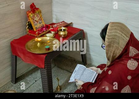 indische Frauen singen heilige Mantren zu Hause für spirituelles Wohlbefinden aus verschiedenen Blickwinkeln anlässlich der durga Puja in indien. Stockfoto