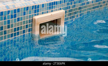 Schmutzige Wand Skimmer Ausrüstung Filtration Schwimmbad System mit Reflexion auf blauem Wasser Pool. Privater Pool, Wartung. Service. Stockfoto