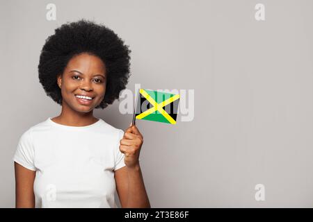 Jamaikanische Frau, die Flagge von jamaikanischer Bildung, Wirtschaft, Staatsbürgerschaft und Patriotismus hält Stockfoto