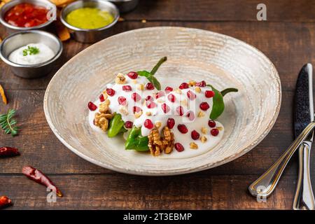 Chiles en Nogada, ein traditionelles mexikanisches Gericht mit Pablano-Chili, gefüllt mit Fleisch und Obst, garniert mit Granatapfelkernen und Walnüssen Stockfoto