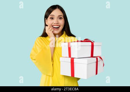 Wunderschönes junges Brünette-Model mit Geschenkboxen Stockfoto