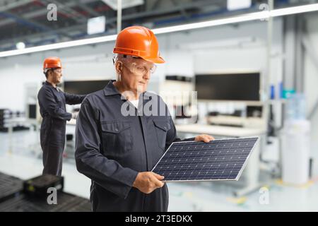 Arbeiter in einer Solarpaneelfabrik, nachhaltige Lösungen für die Energiewirtschaft Stockfoto