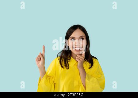 Interessierte hübsche junge Frau, die eureka-Geste zeigt Stockfoto
