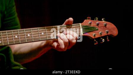 Bild von Fingern, die einen Akkord auf dem Frittbrett einer Akustikgitarre aufnehmen Stockfoto