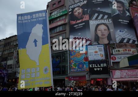 *** STRENG KEIN VERKAUF AN FRANZÖSISCHE MEDIEN ODER VERLAGE - RECHTE VORBEHALTEN ***08. Oktober 2023 - Taipeh, Taiwan: Taiwaner laufen an großen Kampagnenflaggen zur Unterstützung der Unabhängigkeit Taiwans, mit den blauen und gelben Farben der Ukraine, im Bezirk Ximending. Die Flaggen wurden von einer kleinen Gruppe namens "Taiwan Independence Flag Team" gesetzt, die sich für ein Referendum zur Selbstbestimmung einsetzt. Dieses Bild war Teenager am 1. Oktober, dem Nationaltag der Volksrepublik China. Stockfoto