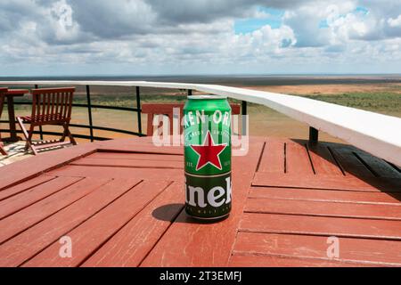 Eine Bierdose Heineken-Bier sitzt auf einem Tisch neben einem Swimmingpool an einem malerischen Aussichtspunkt im Tsavo East National Park, Kenia Stockfoto